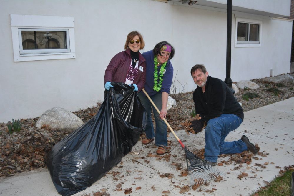 Lori LaRochelle, left, and Julie Moser, center, from the Augusta Downtown Alliance’s Design Committee work with volunteer Randy Moser, right, to clean up Market Square Park.