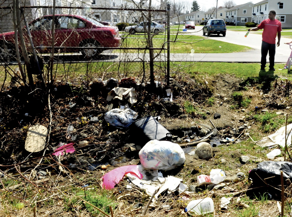 Will Henderson, a resident of the housing project off the Armory Road in Waterville, speaks on Monday about the accumulation of both bags of and loose garbage that lies in a culvert at the intersection of Wilson and Mystic streets. Some residents say the buildings and open space in the area are configured so that a wind tunnel effect results, blowing trash toward areas where barriers prevent it from being blown further along.