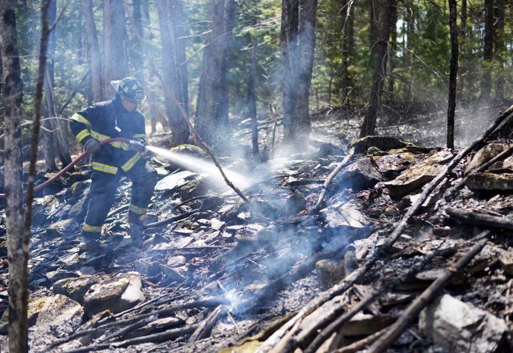 Jonathan Berringer, a firefighter with the Winslow fire department, fights a grass fire on Tuesday.