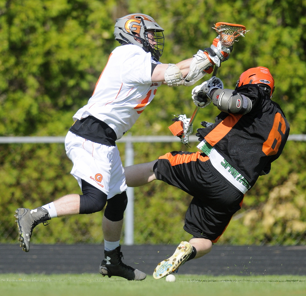 Gardiner Area High School’s Walker Norton, left, checks Winslow High School’s Ray Spaulding during a lacrosse game Wednesday in Gardiner.