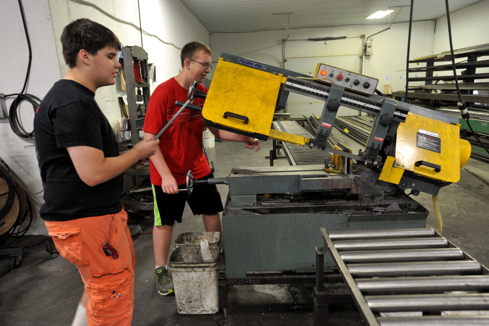 Delsin Klein, 14, left, and Ethan Pullen, 16, fabricate an axle for the Messalonskee robotics team robot on Thursday at Wrabacon in Oakland.