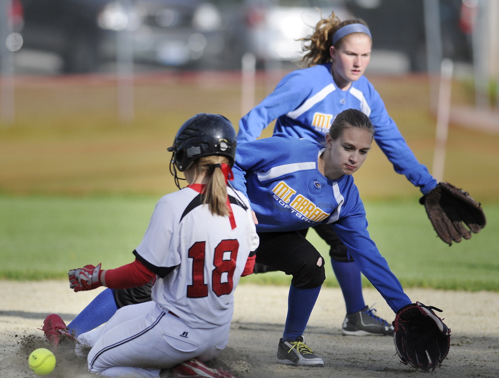 Mount Abram’s Abby Holland, right, and Bailey Beers chase a throw to second base that struck Hall-Dale runner Eva Shepherd during a Mountain Valley Conference game Wednesday.