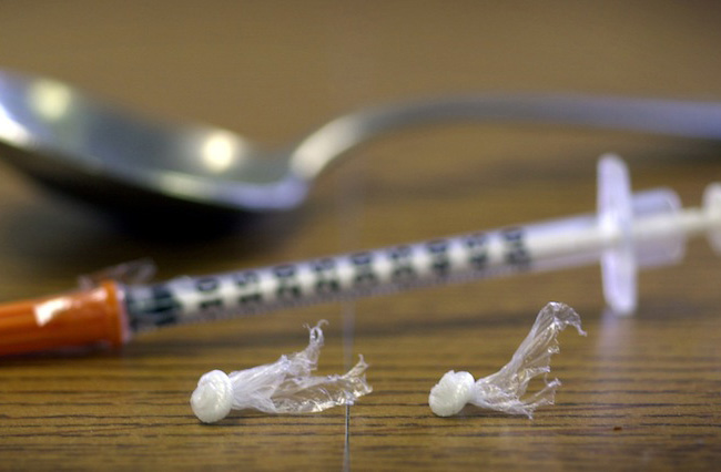 Packets of heroin, a syringe and a spoon are displayed at the Drug Enforcement Agenecy in this file photo from Dec. 19, 2002, in Portland. 