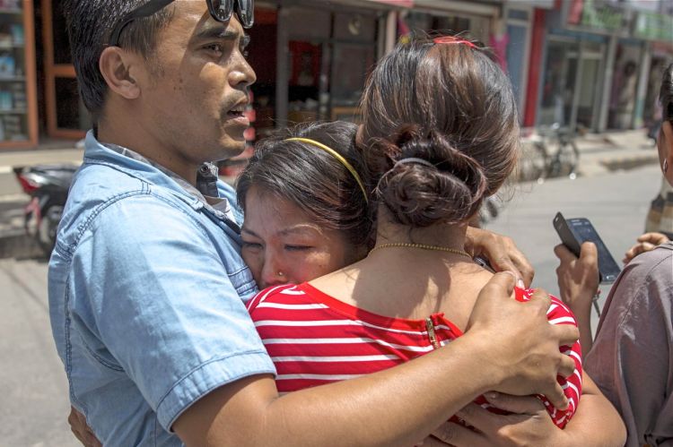 Local residents comfort each others during an earthquake in central Kathmandu Tuesday. At least four people were killed and more than 300 injured in Nepal after the magnitude 7.3 earthquake shook the Himalayan nation. Reuters