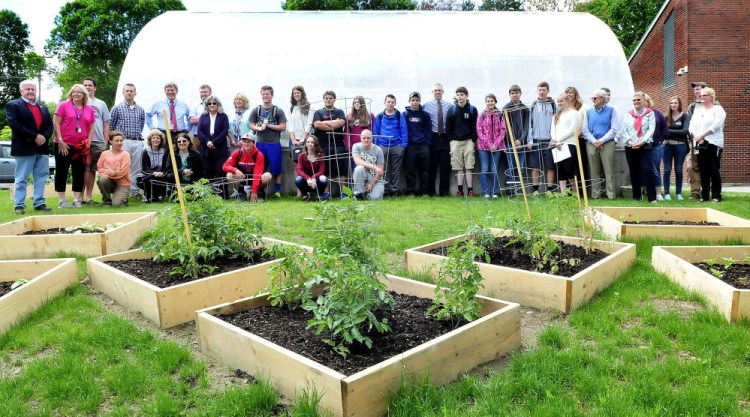 Messalonskee High School students, staff members and area business contributors stand around the new greenhouse during an official opening Wednesday at the Oakland school.