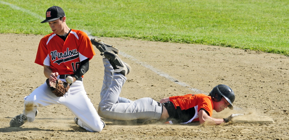 Winslow first baseman Jon Nerney hangs on to the ball, but Gardiner baserunner Eli Fish slides back to the bag safely during a KVAC B game Thursday.