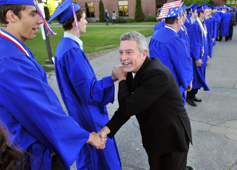 Social studies teacher Glenn Hutchinson walks the line Thursday congratulating graduates before the Messalonskee High School graduation at the Augusta Civic Center.