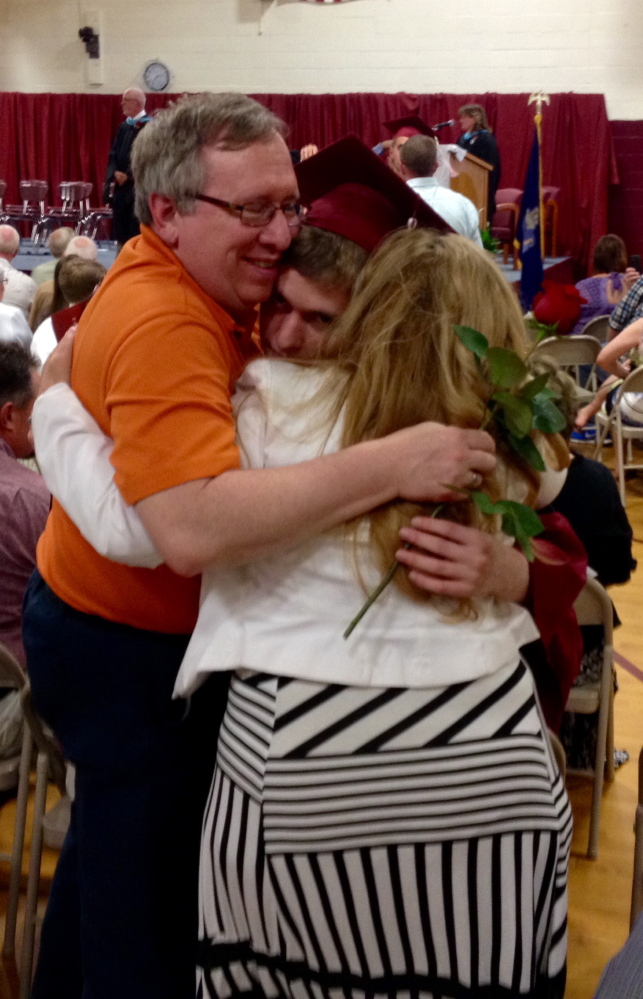 Richmond High School senior Erik Sanford hugs his parents, Alan and Deborah Sanford, during the graduation ceremony Saturday in the school gymnasium in Richmond.