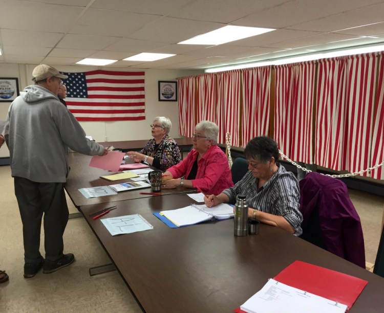 Staff photo by Douglas McIntire
Wilton poll volunteers, from left, Hazel Flagg, Carolyn Smith and Jean Rand, check in voters for the town election Tuesday.