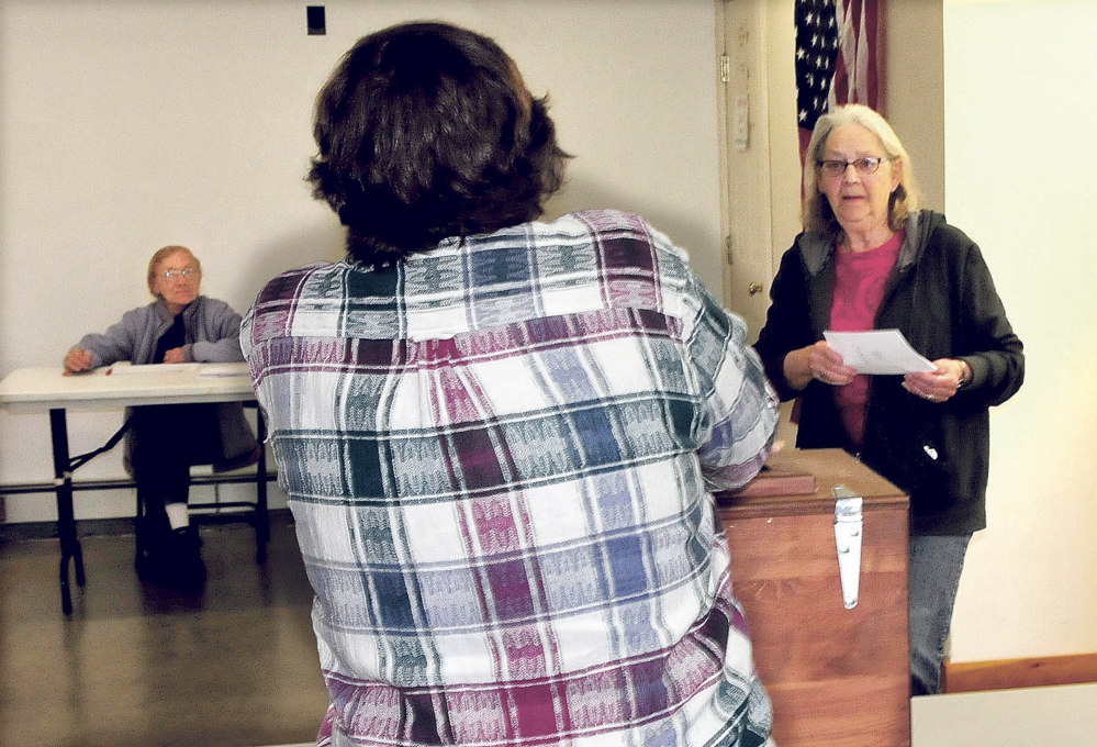 Resident Janne Haines, right, casts her SAD 58 ballot as clerk Marie Pillsbury opens ballot box in Avon on Tuesday. Clerk Josephine Gilcrest is in background. Haines was the eighth voter by 2 p.m. on a slow election day. Residents of Phillips, Strong, Avon and Kingfield voted on the SAD 58 budget, which had been reduced from $9.4 million to about $260,000.