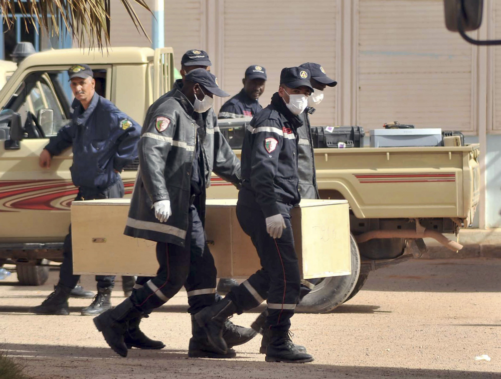 In this Jan. 21, 2013 file photo, Algerian firemen carry a coffin containing the body of a person killed during the gas facility hostage situation at the morgue in Ain Amenas, Algeria.