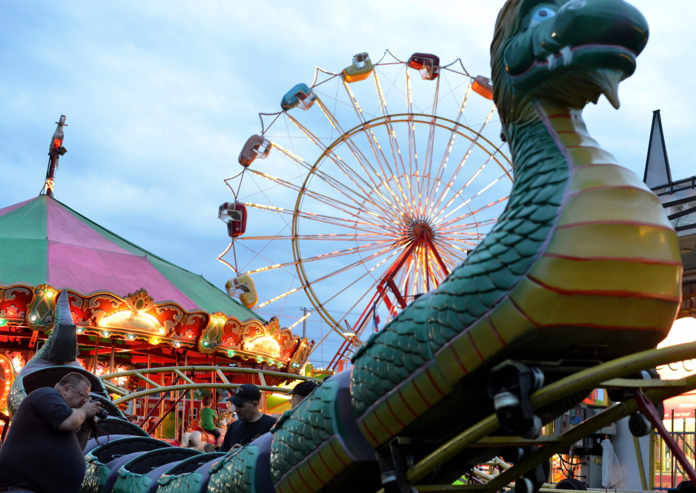 Inspectors from the Office of State Fire Marshal investigate the ride that malfunctioned at Smokey’s Greater Shows carnival at Head of Falls in Waterville on Friday, injuring three children. The investigation into the Dragon Wagon accident is continuing, officials said Monday.