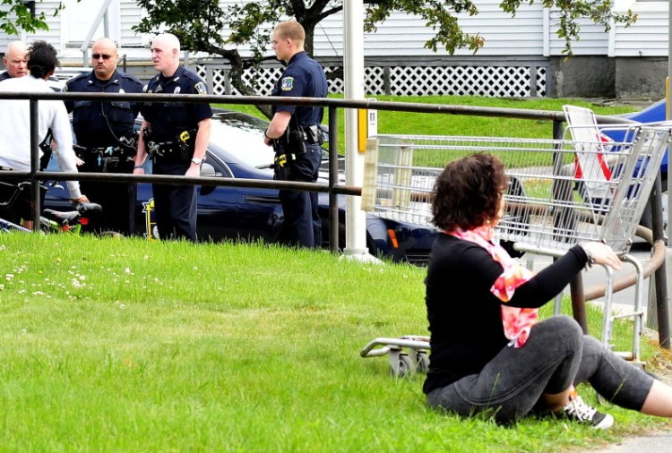 Codi Parker, foreground, was arrested after allegedly attacking a man, left, talking to police on Spring Street in Waterville Monday.