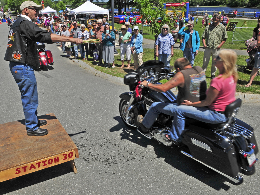 The Rev. Jack Fles sprinkles water on motoryclists Saturday during the Blessing of the Bikes in Waterfront Park in Gardiner. The event was part of the Greater Gardiner River Festival.