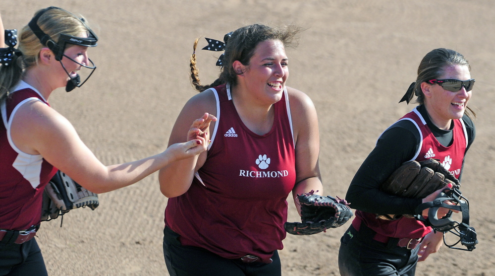 Richmond left fielder Emily Douin, center, is congratulated by third baseman Kelsea Anair, left, and pitcher Meranda Martin after she caught a popup to end the fifth inning of the Class D state championship game Saturday on Bailey Field at St. Joseph’s College in Standish.