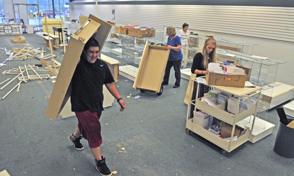 People clean out the former Beverly’s Card and Gift on Tuesday at the Turnpike Mall in Augusta.