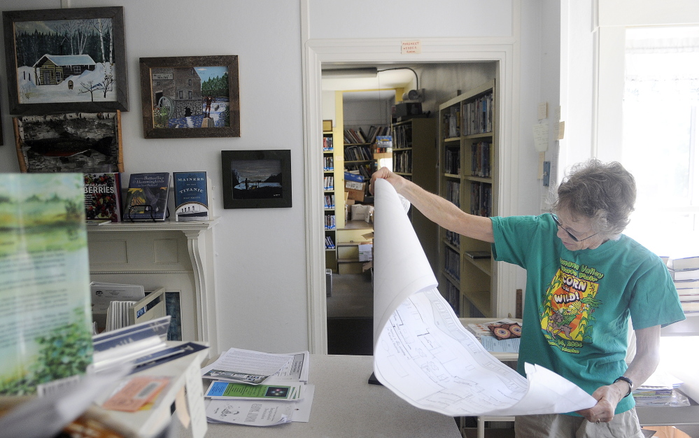 Alice Olson examines plans for expansion of Dr. Shaw Memorial Library on Wednesday in Mount Vernon. Olson is the head librarian.