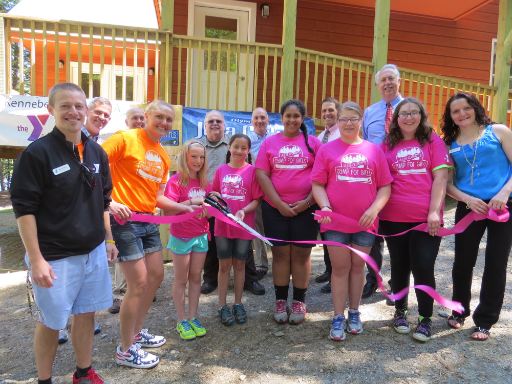 Along with the YMCA staff and community leaders, Olympian Julia Clukey helps campers Talia Nussinowl, Gabby Sienko, Fifi Mathieu, Cali Berhar and Lucy Pruett cut the ribbon at the ceremony on Wednesday, June 17, at Julia Clukey’s Camp for Girls at Camp KV in Readfield.