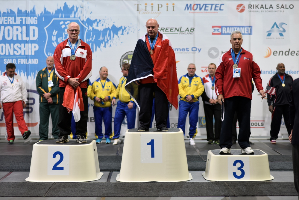 John LaFlamme, right, is presented with a bronze medal in the deadlifte competition at the Iternational Powerlifting Federation Classic World Championship in Salo, Finland.
