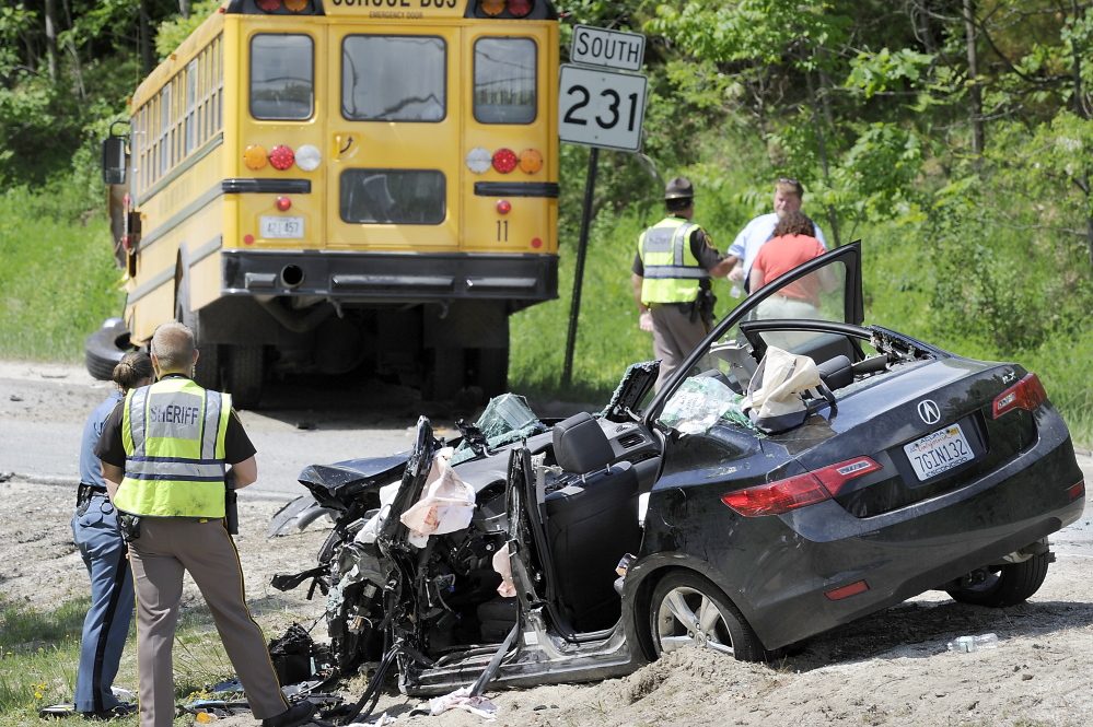 School officials talk with Capt. Don Goulet of the Cumberland County Sheriff”s Office as law enforcement officers stand by the car that crashed into a school bus carrying 3rd- and 4th-graders Wednesday morning.