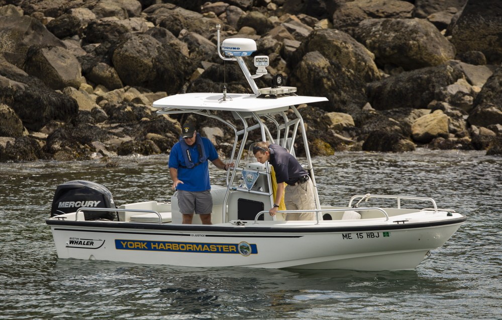 Two men in the York harbor master’s boat search for a missing person in the water near Nubble Light in Cape Neddick on Thursday.
