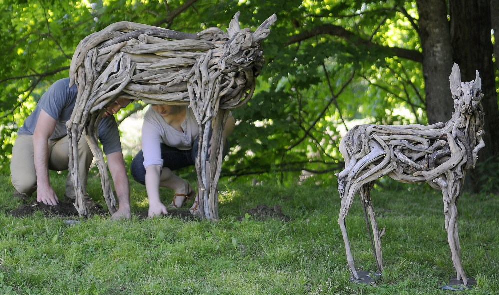 Benjamin Stoodley and Arielle Cousens install their sculpture “Navi” on the lawn of the Vaughan Homestead on Friday in Hallowell.