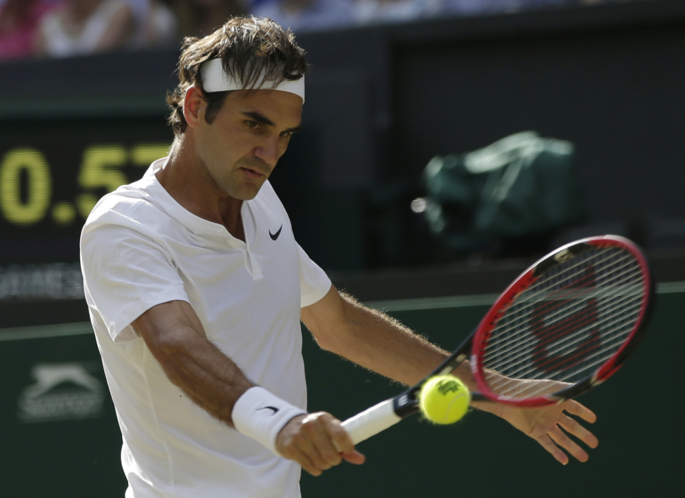 Roger Federer returns a ball to Andy Murray during their men’s singles semifinal match Friday at the All England Lawn Tennis Championships in Wimbledon, London. Federer won the match.