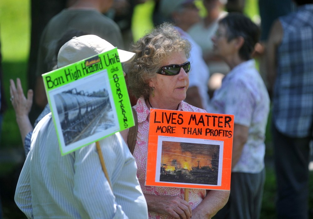 Protesters carrying signs opposing the transport of hazardous materials by rail gather for a demonstration Saturday in Veteran’s Memorial Park in Fairfield.