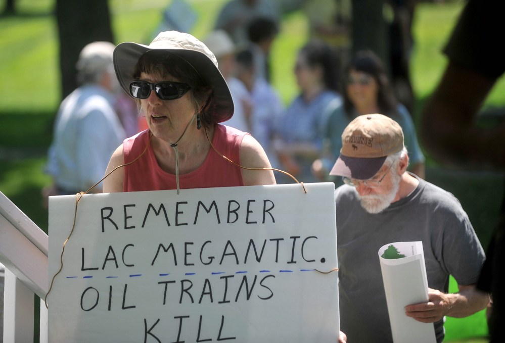 Protesters carrying signs opposing the transport of hazardous materials by rail gather for a demonstration Saturday in Veteran’s Memorial Park in Fairfield.