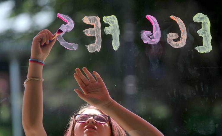 Delanie Nichols, 10, of Pittsfield, paints a Main Street business window in Pittsfield on Thursday, day four of the 43rd annual Central Maine Egg Festival.