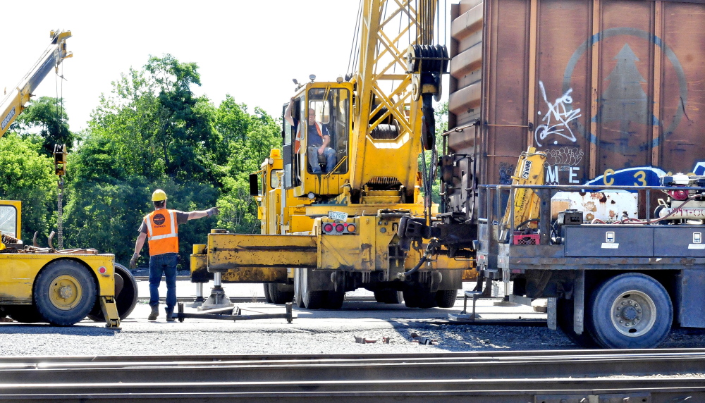 Pan Am workers repair a railroad car set of wheels at the Waterville yard on Wednesday.