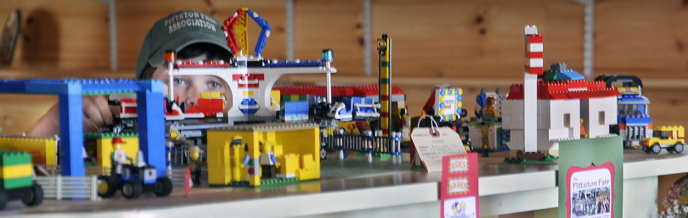 Jared Weeks, 9, tests the Ferris wheel he assembled out of Legos that he displayed in the Exhibition Hall at the Pittston Fair on Wednesday.