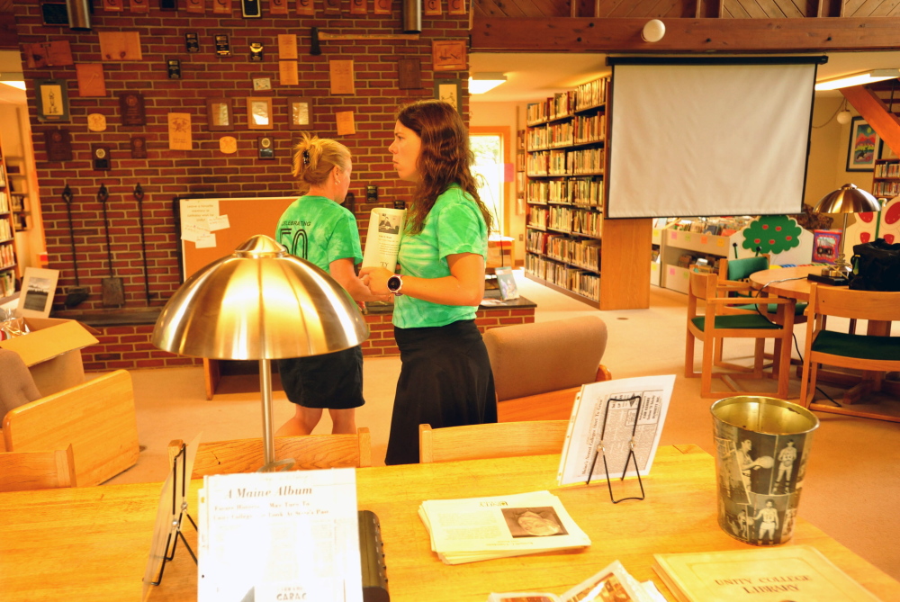 Jlynn Frazier, right, and Erica Hutchinson prepare for the arrivals of alumni and college friends at Clifford Hall for the 50th anniversary of Unity College on Friday.