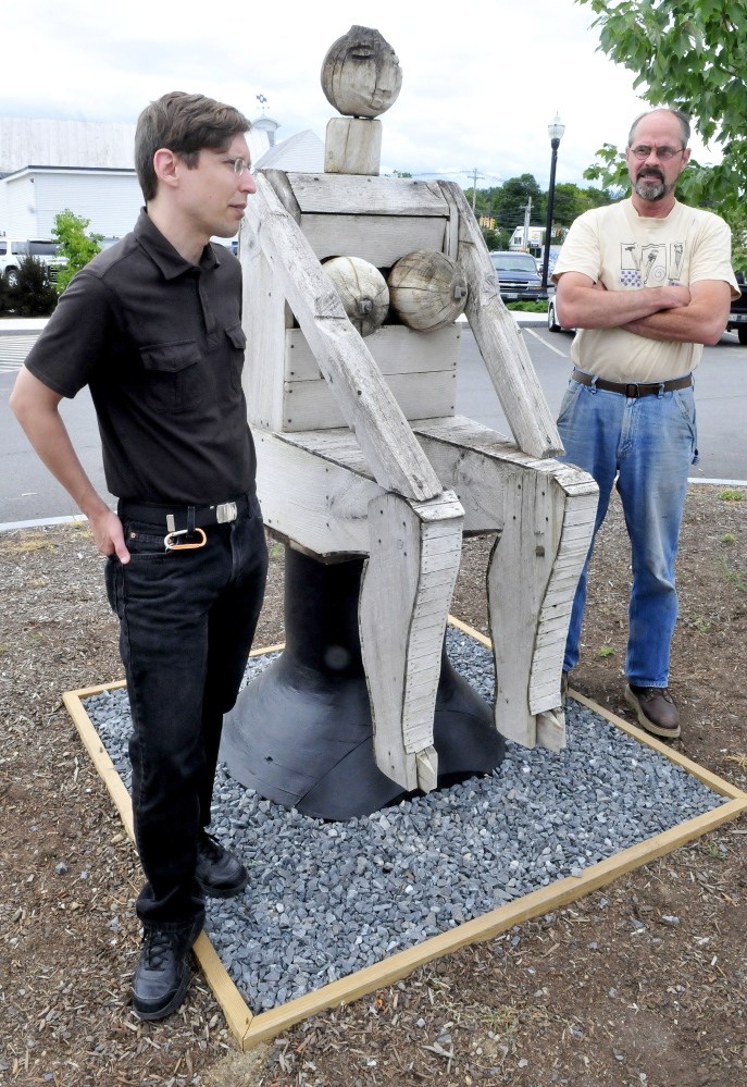 Dugan Murphy, left, executive director of Main Street Skowhegan, and Steve Dionne of Dionne & Sons Builders speak on Thursday beside a Bernard Langlais sculpture “Seated Woman.”
