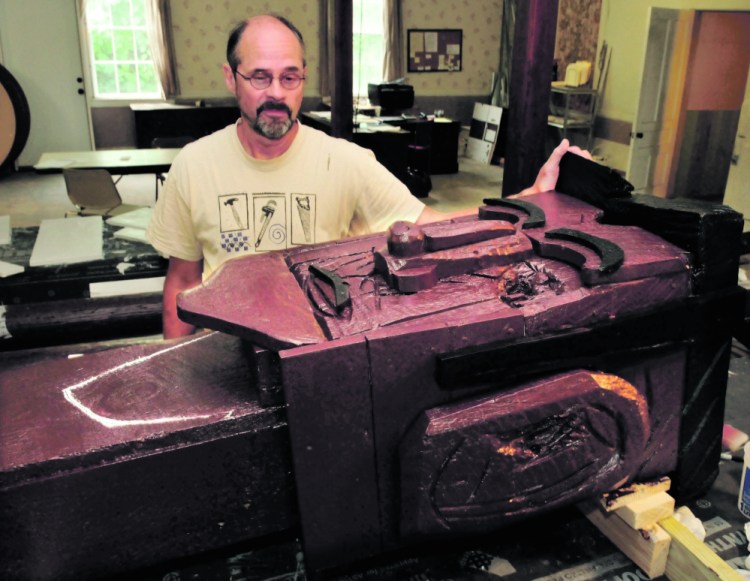 Steve Dionne is restoring the “Basketball Player” sculpture by Bernard Langlais in Skowhegan on Thursday.