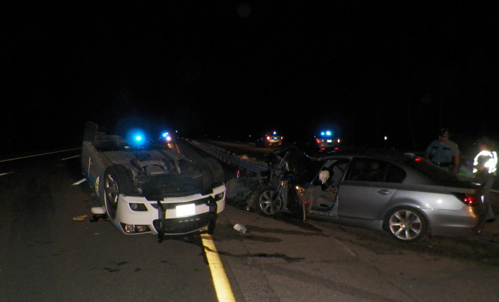 A Wells police cruiser is upside down on Interstate 95 early Saturday morning. The driver of a BMW that crashed into the cruiser suffered multiple injuries.