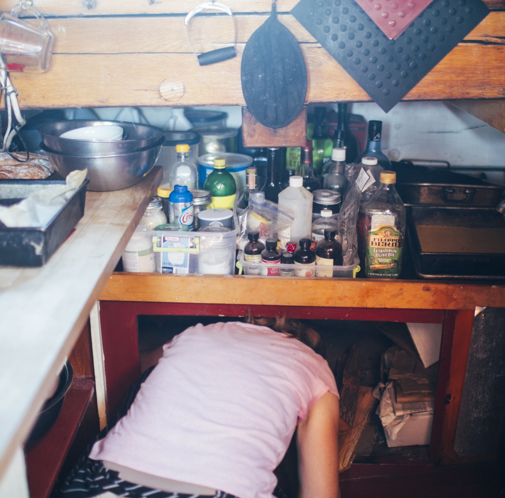 Chef Anne Mahle squeezes under a counter in the J. & E. Riggin’s galley during the Great Schooner Race in Rockland on Friday.