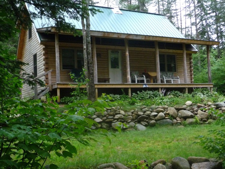 A photo taken Saturday shows a cabin in Byron, where four young adults from Massachusetts and a dog found were dead. The suspected cause is carbon monoxide poisoning from a generator that had been running in the basement. 