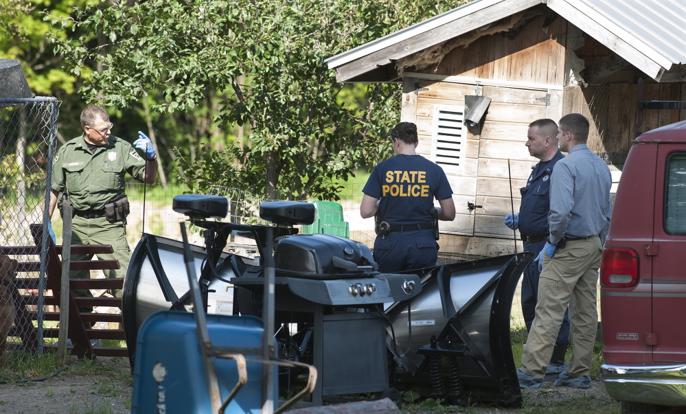 State police and a game warden talk Friday near the scene of a suspicious barn fire in Benedicta. The fire may have been set by Anthony Lord, who went on a rampage later Friday. Kevin Bennett/Special to the Press Herald