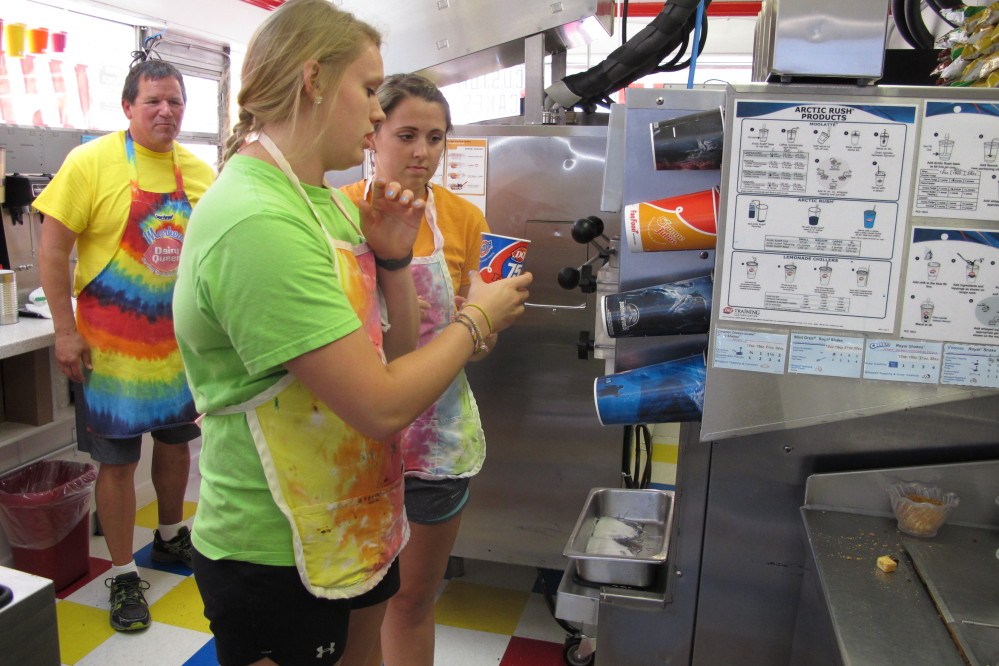 A worker at the Dairy Queen in downtown Moorhead, Minn., shows another how to make a “Blizzard.” The Moorhead store opened in 1949 and draws crowds despite the fact it has no indoor seating or drive-thru, thanks to conducting business the old-fashioned way.