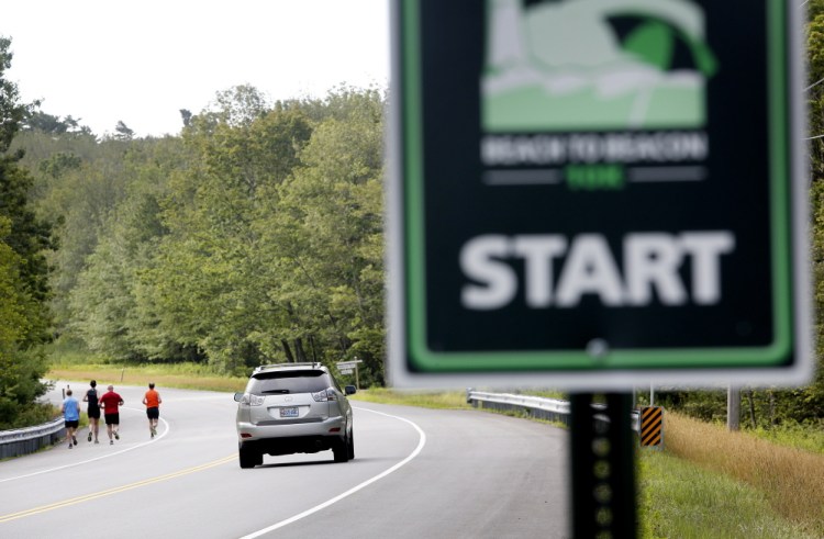 Runners move along Route 77 on Saturday near the starting line of the TD Beach to Beacon 10K. The event draws world-class runners and well over 10,000 total participants and spectators.