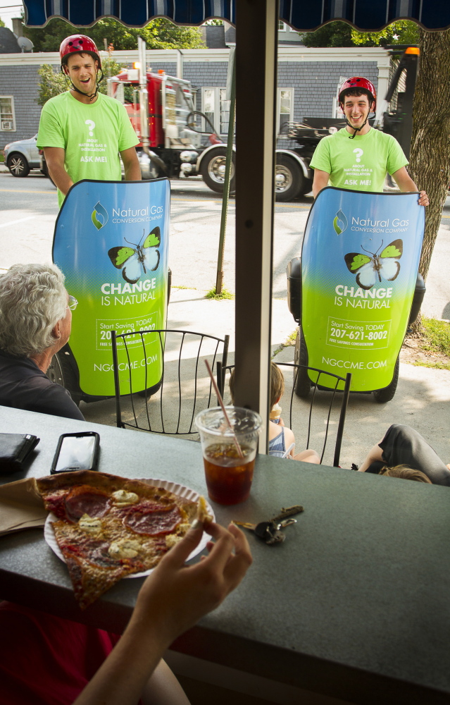 Tim Gilboe and Blake Ivers of EMG3 marketing group of Falmouth talk to customers outside Hilltop Coffee and Otto Pizza in Yarmouth about the benefits of converting to natural gas.