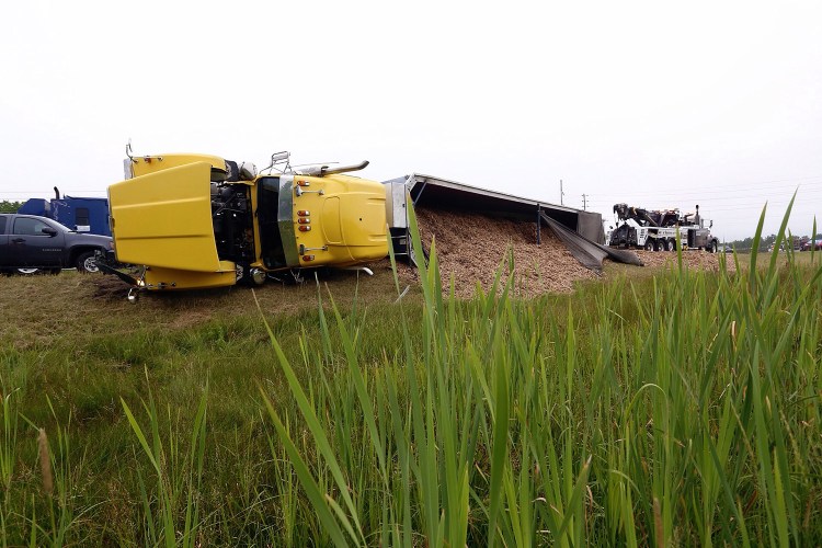 A tractor-trailer lies on its side after overturning on the northbound side of Interstate 95 near The Maine Maine in South Portland on Tuesday.