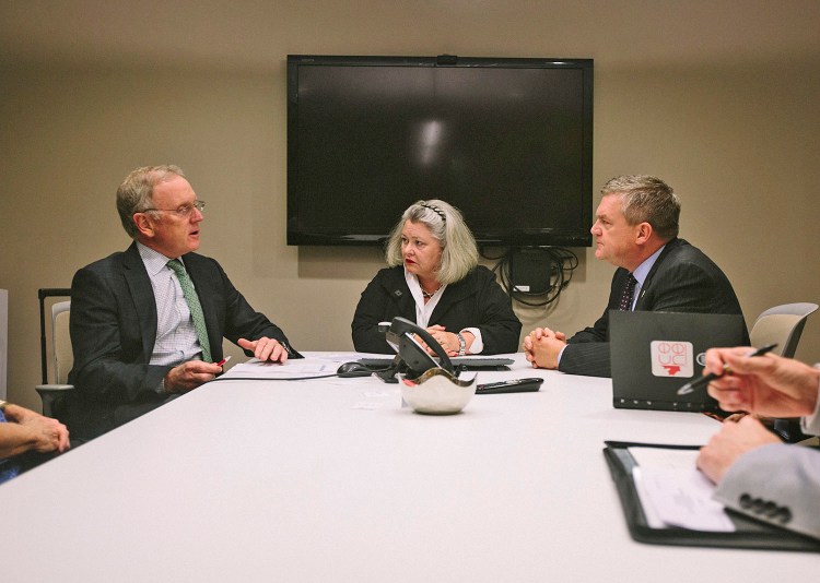 Brenda Garrand and David Alward, right, speak with Kepware founder Corson Ellis at Kepware in Portland on Tuesday. Whitney Hayward/Staff Photographer