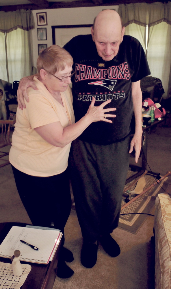 Dottie Shorey helps her husband David in their home in Palermo recently. David has health issues and requires hospice care.