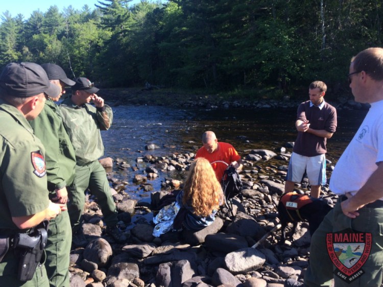 Erica LaChance, who was found Monday morning after becoming lost in the Moxie Falls area the previous night, is surrounded by game wardens.