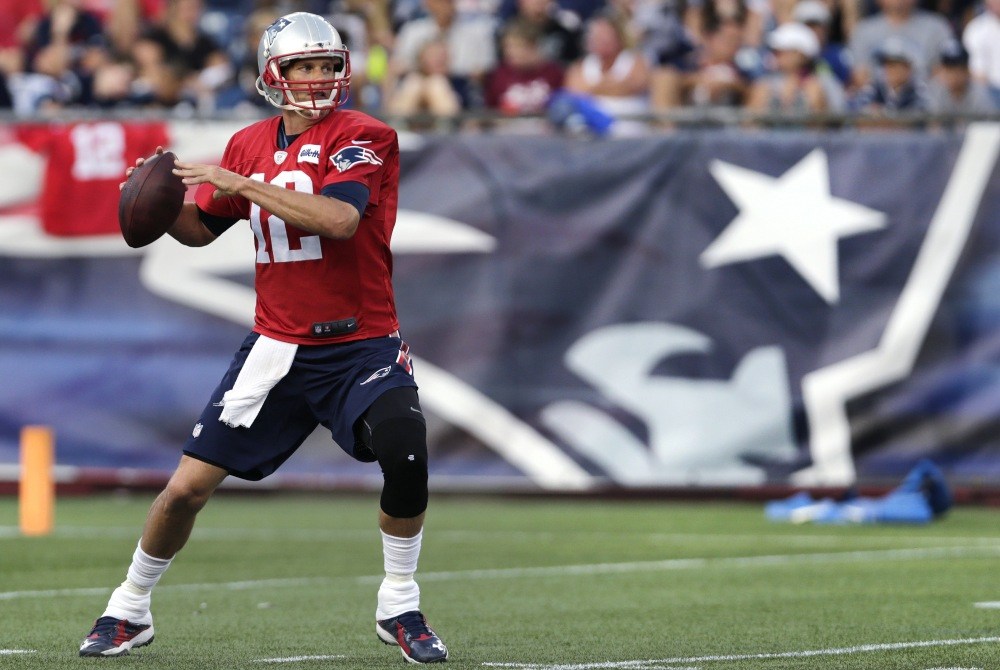 In this Aug. 5 photo, New England Patriots quarterback Tom Brady sets to pass during training camp in Foxborough, Mass. Brady missed Tuesday’s practice to prepare for his court case Wednesday in Manhattan.