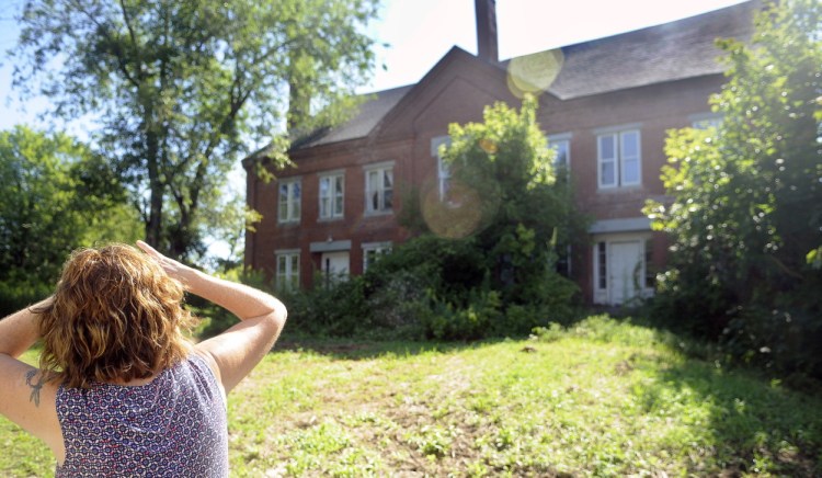 Barbara Bowley inspects the Hathorn Block in Richmond on Thursday. Bowley owns Annabella’s Bakery & Cafe with her daughter, Stacy LaBombard, which is across the street from the neglected structure.