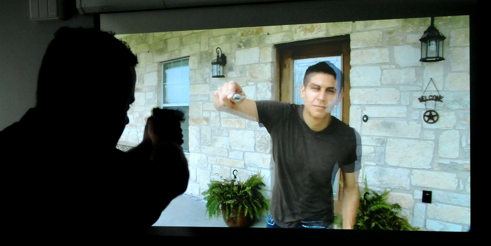 Waterville police officer Damon Lefferts takes aim with a laser pistol at the projected image of an assailant with a knife while using the laser shot training system at the department on Wednesday. The system allows an officer to make quick and appropriate decisions while confronting a virtual hostile subject.