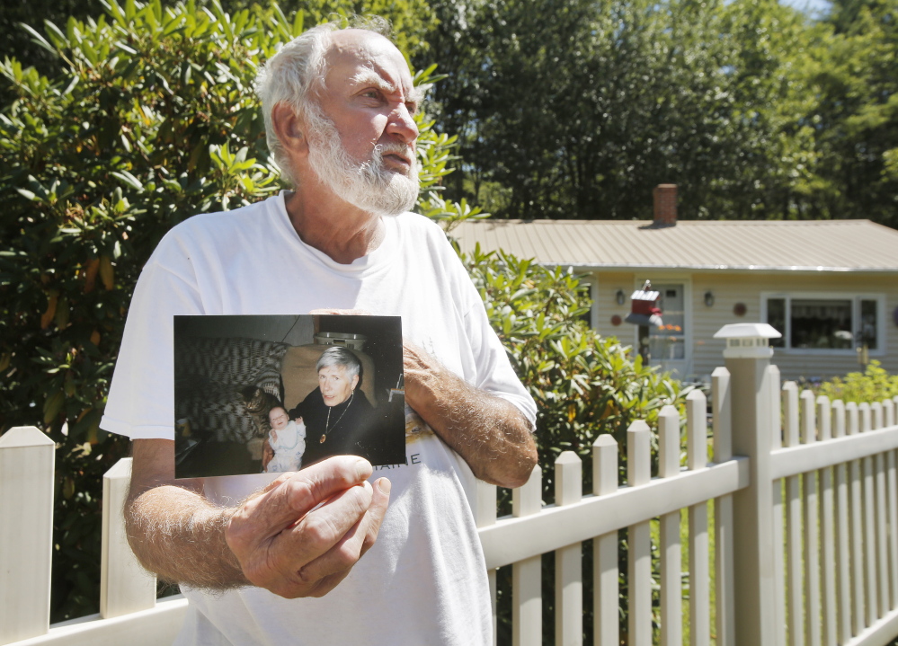 Robert Douglas holds a photo taken 17 years ago of his late wife, Rita, holding their granddaughter Harley. The Harpswell couple was planning to celebrate their 49th wedding anniversary on Sunday.